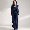 Frau trägt marineblauen Stehkragen-Blazer mit passender Weithose als Set, Ganzkörperansicht