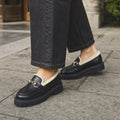 Herlinde | Plateau-Loafer mit Fleecefutter und Kettensteg Schwarz / Gold – Gestyltes Editorial-Foto